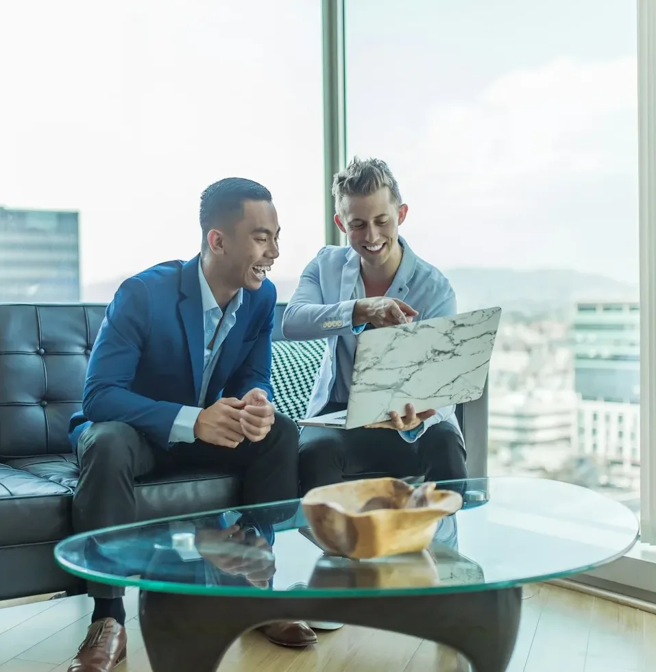 two men in suit sitting on sofa