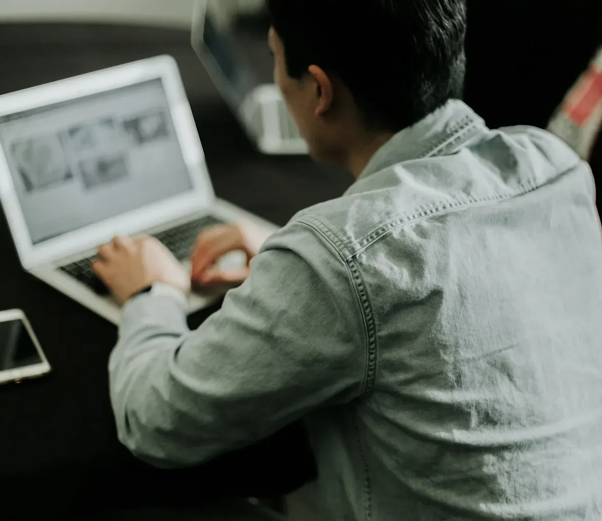 a man sitting in front of a laptop computer