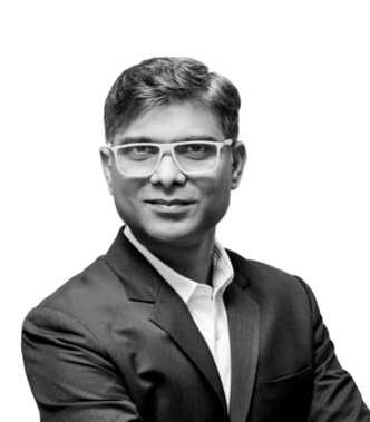 Man in suit wearing glasses, black and white.